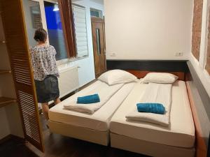 a woman standing next to two beds in a room at studio in Sibiu