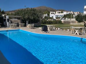 a large blue swimming pool with a table and chairs at Hotel Anezina in Drios