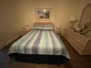 a bedroom with a bed and two dressers and a mirror at Beachfront Venice Casa de Villa in Venice