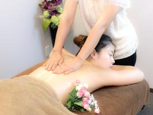 a woman getting a massage from a therapist at Matsuyama New Grand Hotel in Matsuyama