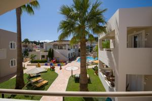 a view of a courtyard with palm trees and a pool at Toxo Hotel in Plataniás