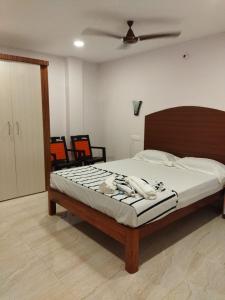 1 dormitorio con 1 cama y ventilador de techo en Aashrey Bed and Breakfast, en Port Blair