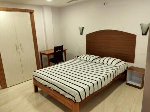 a bedroom with a large bed with a wooden headboard at Aashrey Bed and Breakfast in Port Blair