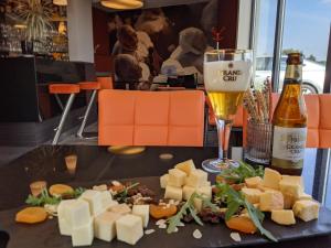 a plate of cheese and a glass of beer at Orange Hotel La Louvière in La Louvière