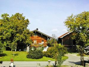 a house with a porch and a yard with trees at Ferienwohnung Held in Waging am See