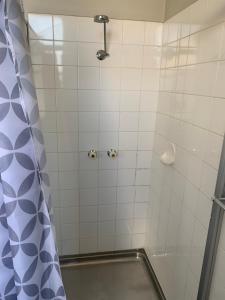 a shower with a blue and white shower curtain at Premier Hotel Collie in Collie +15 photos