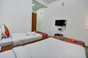 a hotel room with two beds and a tv at FabExpress PAS Residency - Nr Marina Beach in Chennai