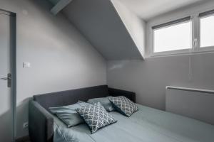 um quarto com uma cama com almofadas em Joli appartement - 4min à pieds de la plage em Asnelles