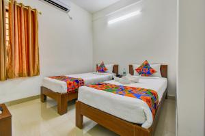 a bedroom with two beds and a window at FabExpress PAS Residency - Nr Marina Beach in Chennai