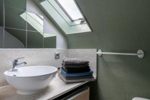 a bathroom with a sink and a skylight at Joli appartement - 4min à pieds de la plage in Asnelles