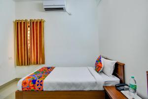 a bedroom with a bed and a dresser at FabExpress P.A.S Residency in Chennai