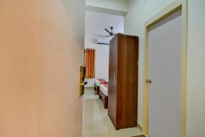 a hallway with a door and a room with a bed at FabExpress PAS Residency - Nr Marina Beach in Chennai