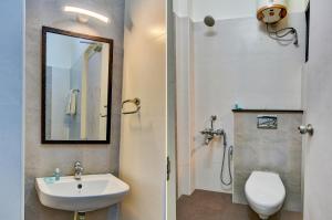 two images of a bathroom with a sink and a toilet at FabExpress PAS Residency - Nr Marina Beach in Chennai