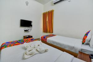 a hotel room with two beds with towels on them at FabExpress PAS Residency - Nr Marina Beach in Chennai