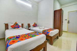 a bedroom with two beds with colorful sheets at FabExpress PAS Residency - Nr Marina Beach in Chennai
