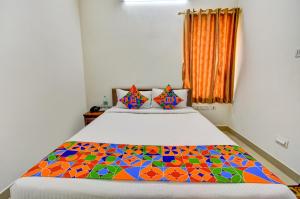 a bedroom with a bed with a colorful quilt at FabExpress PAS Residency - Nr Marina Beach in Chennai