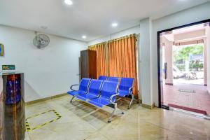 a group of blue chairs in a waiting room at FabExpress PAS Residency - Nr Marina Beach in Chennai