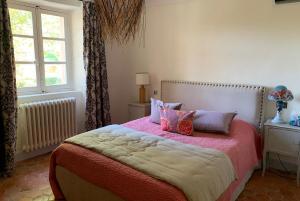 Schlafzimmer mit einem Bett mit rosa Bettwäsche und Kissen in der Unterkunft Villa Terrubi en Provence au Domaine Fontainebleau in Le Val