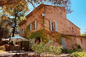 ein altes Backsteingebäude mit einem Regenschirm davor in der Unterkunft Villa Terrubi en Provence au Domaine Fontainebleau in Le Val