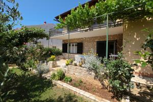 a house with a garden in front of it at Apartment Ema in Premantura