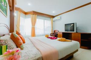 a hotel room with a bed with a television on it at RK Guesthouse in Patong Beach