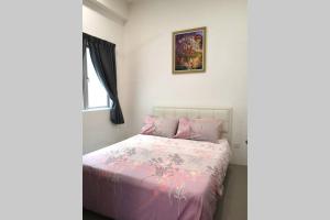 a bedroom with a bed with a pink comforter at W58 WarmStay atGoldenHill NightMarket 2R WiFi CarPark in Tanah Rata