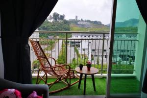 a balcony with two chairs and a table and a window at W58 WarmStay atGoldenHill NightMarket 2R WiFi CarPark in Tanah Rata