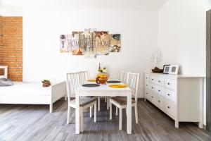 biała jadalnia z białym stołem i krzesłami w obiekcie Victus Apartamenty, Apartament Riviera w mieście Sopot