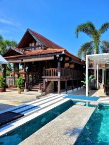 a house with a swimming pool in front of a house at Villapadu Desa in Kuala Terengganu