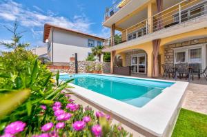 a villa with a swimming pool and a house at One-Bedroom Apartment Crikvenica near Sea 2 in Dramalj