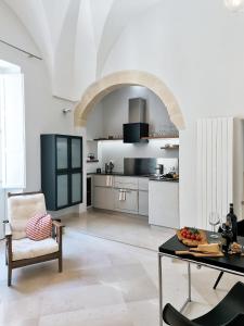a living room with a table and a kitchen at Palazzo Charlie in Lecce
