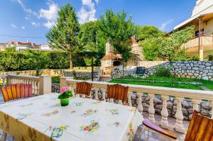 a table and chairs on a patio with a stone wall at One-Bedroom Apartment Crikvenica 6 in Dramalj