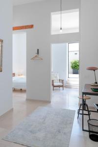 a white room with a bed and a table at Palazzo Charlie in Lecce