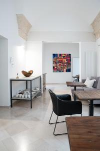 een woonkamer met tafels en stoelen en een bank bij Palazzo Charlie in Lecce