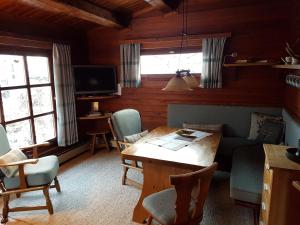 a living room with a table and chairs and a tv at Blockhaus - Die Zwergenbaude - in Braunlage
