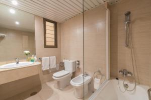 a bathroom with a toilet and a sink and a shower at Hotel Cristina by Tigotan Las Palmas - Adults Only in Las Palmas de Gran Canaria