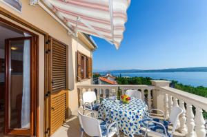 a balcony with a table and chairs and a view of the water at Two-Bedroom Apartment Crikvenica 5 in Dramalj