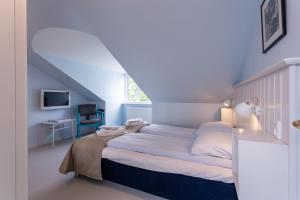 a bedroom with a bed with a blue wall at Rødvig Kro og Badehotel in Rødvig
