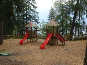 two playground equipment in a park with red slides at The white fox's family home - Veysonnaz in Veysonnaz