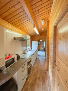 
a kitchen with a wooden floor and wooden cabinets at Avon Tyrrell Outdoor Activity Centre in Bransgore

