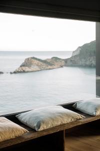dos almohadas sentadas en un banco frente a una ventana en Apartaments Cap Sa Sal, en Begur