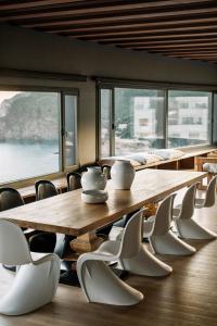een grote houten tafel en stoelen in een kamer met ramen bij Apartaments Cap Sa Sal in Begur