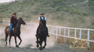 two people riding horses on a dirt track at Bujtina e Muriqit in Shkodër