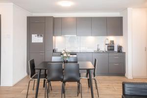 - une cuisine et une salle à manger avec une table et des chaises dans l'établissement SKYLINE Exclusive Penthouse Apartments, à Bâle