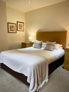 a bedroom with two beds with white sheets and pillows at The Horse & Farrier in Otley