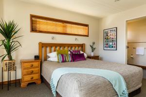 Un dormitorio con una cama grande y una ventana en Beach House Studios, en Napier
