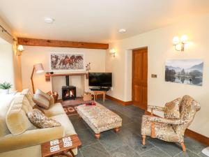 a living room with a couch and a fireplace at Eagle Farmhouse in Glenridding