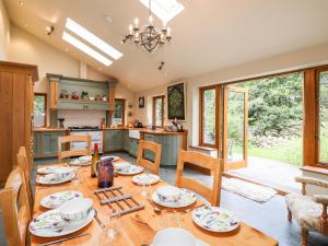 comedor y cocina con mesa y sillas en Eagle Farmhouse, en Glenridding