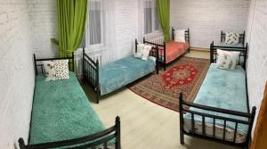 a living room with three beds and a rug at Kolsay Aisha in Saty