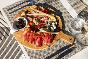 a wooden plate of food on a table at Hotel Osam - Adults Only in Supetar